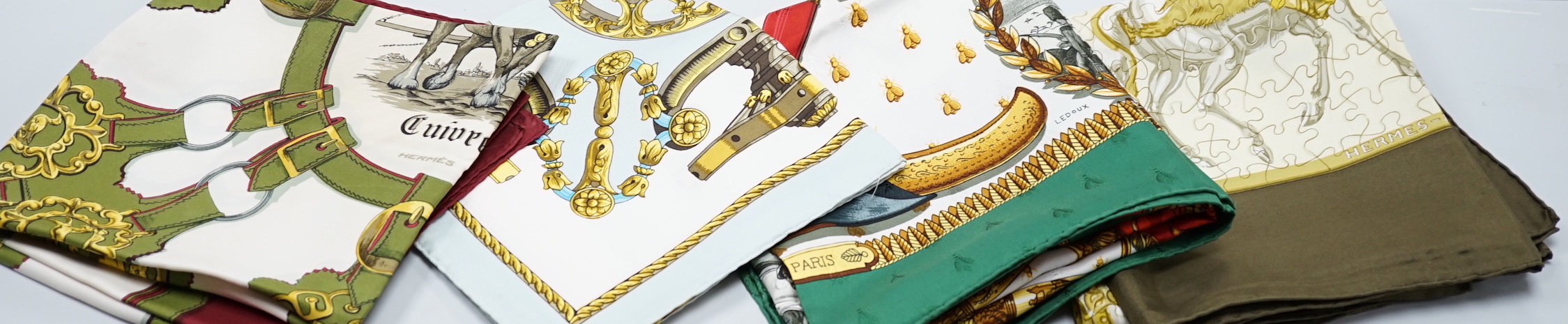 Four vintage Hermes silk scarves including two retailed by Harrods comprising Cuivreries, Roues de Canon, Napoleon and Puzzle